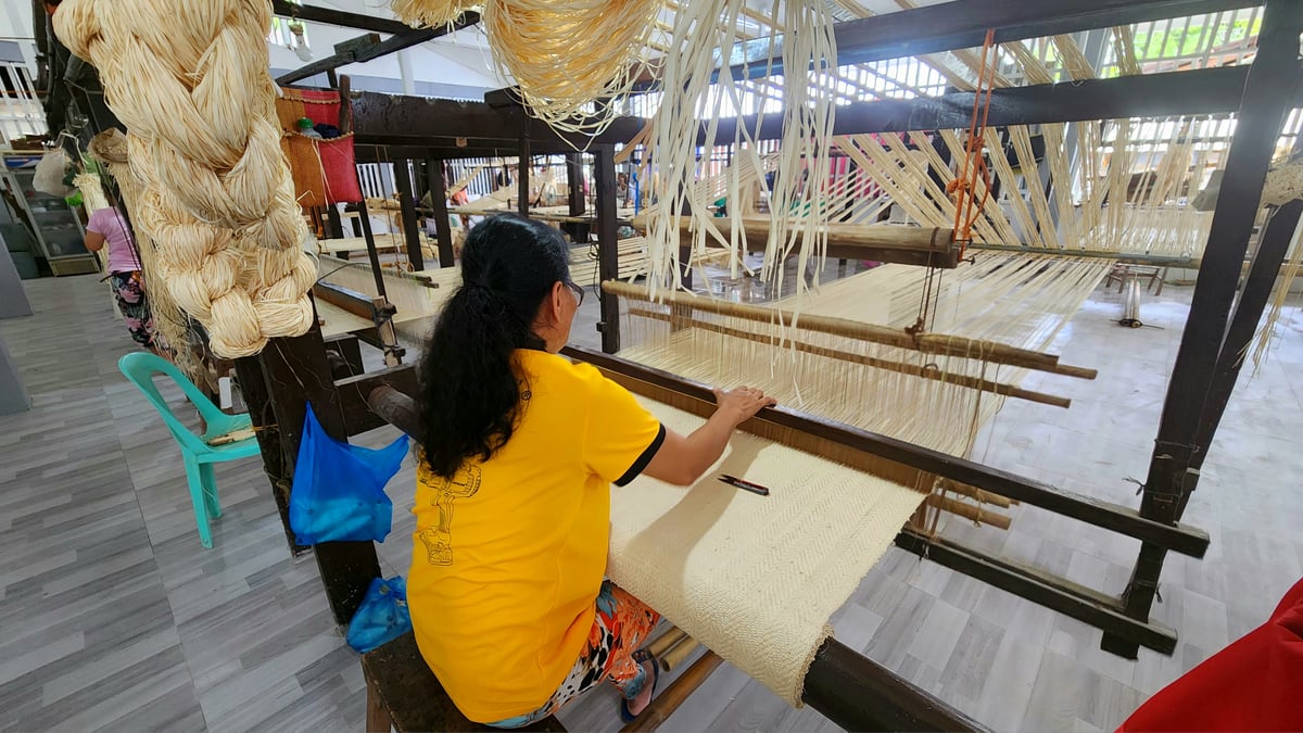 A weaver working on a loom in Tubigon.